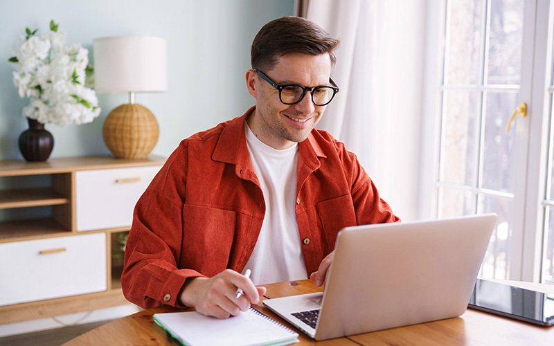 ragazzo sulla scrivania che sorride guardando il computer